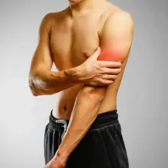 Mężczyzna trzymający się za ramię z zaznaczonym bólem w bicepsie.